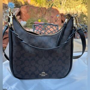 COACH Jules Hobo bag in brown and black coated canvas.